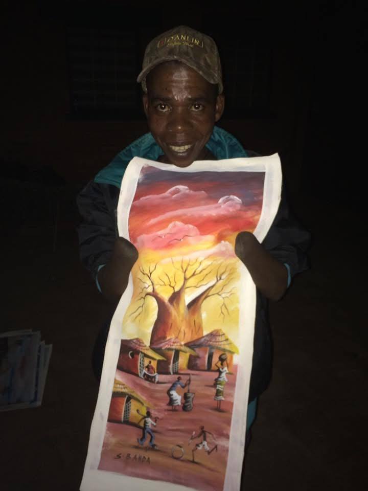 Sam Banda showing one of his landscape paintings that is hanging in my home.
